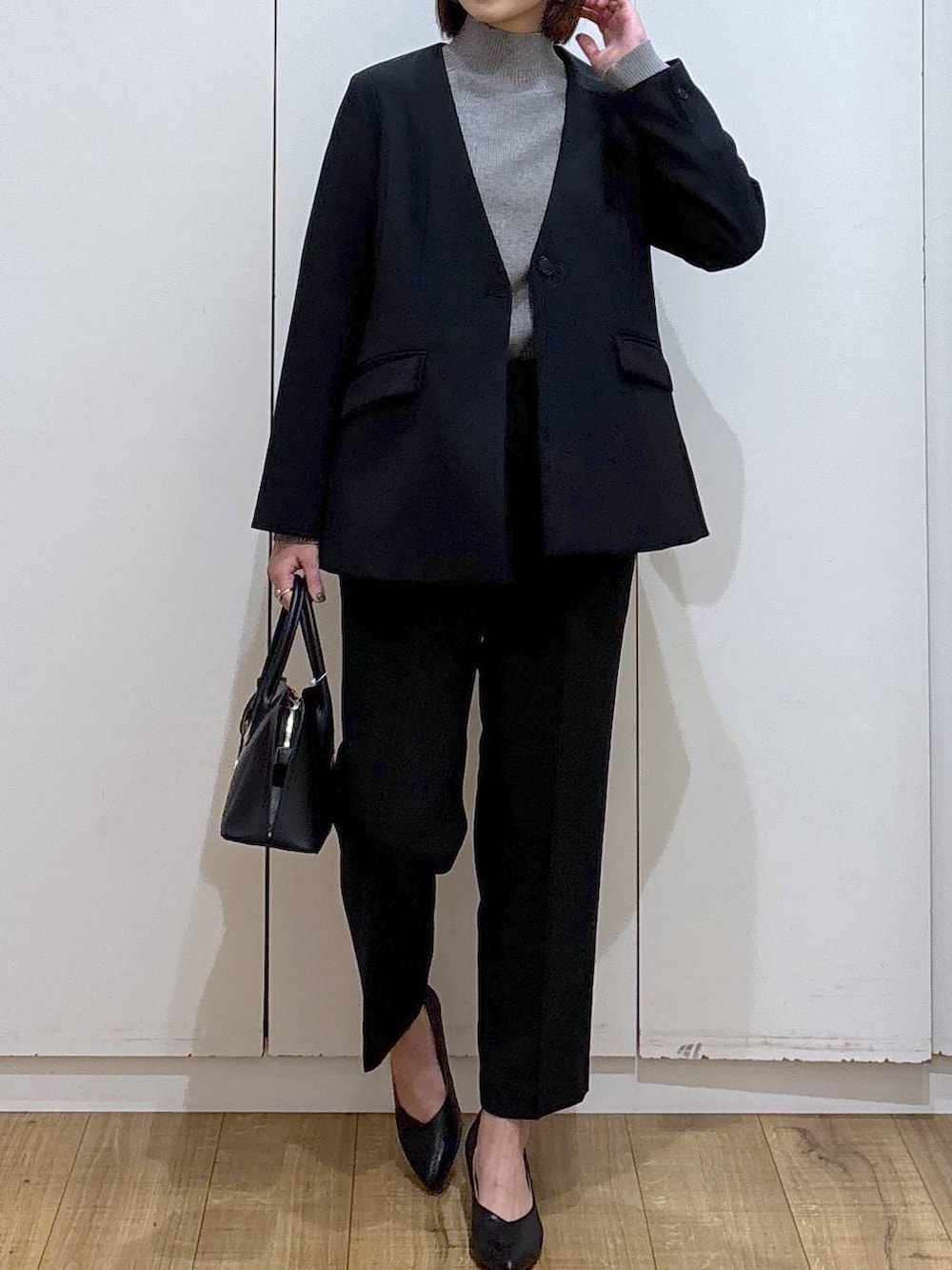 ブラック系のショルダーバッグ、ブラック系のパンプス、グレー系のニット/セーターを着用したレディースの冬コーディネートの7枚目の写真