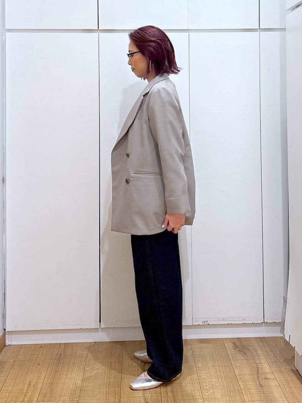 ブルー系のデニムパンツ、シルバー系のパンプス、ベージュ系のテーラードジャケットを着用したレディースの春コーディネートの3枚目の写真