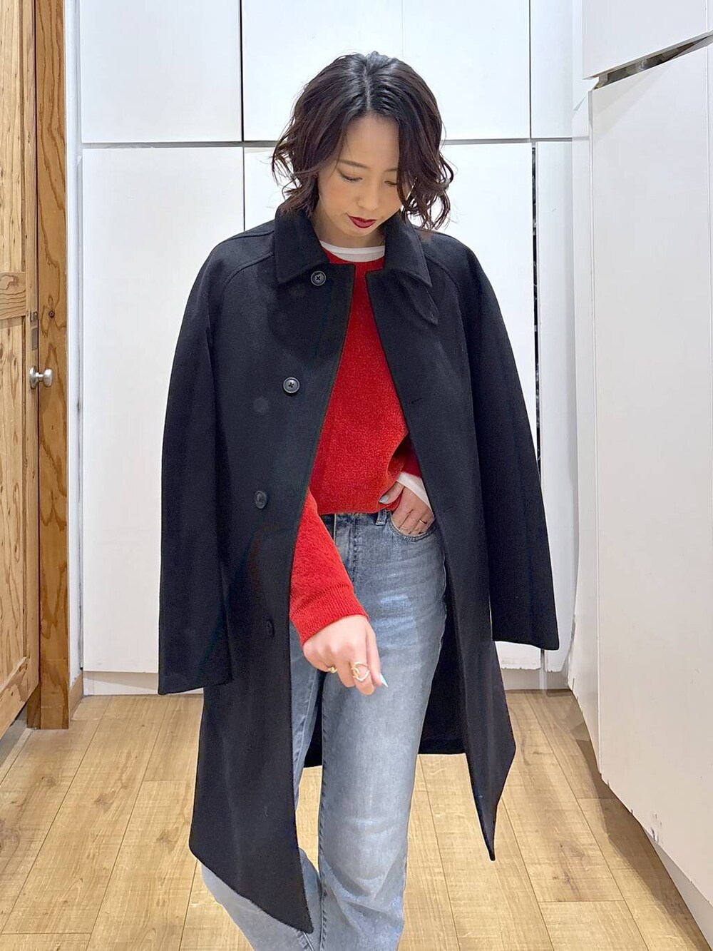 ブラック系のローファー、ブラック系のステンカラーコート、ブルー系のデニムパンツを着用したレディースの冬コーディネートの5枚目の写真