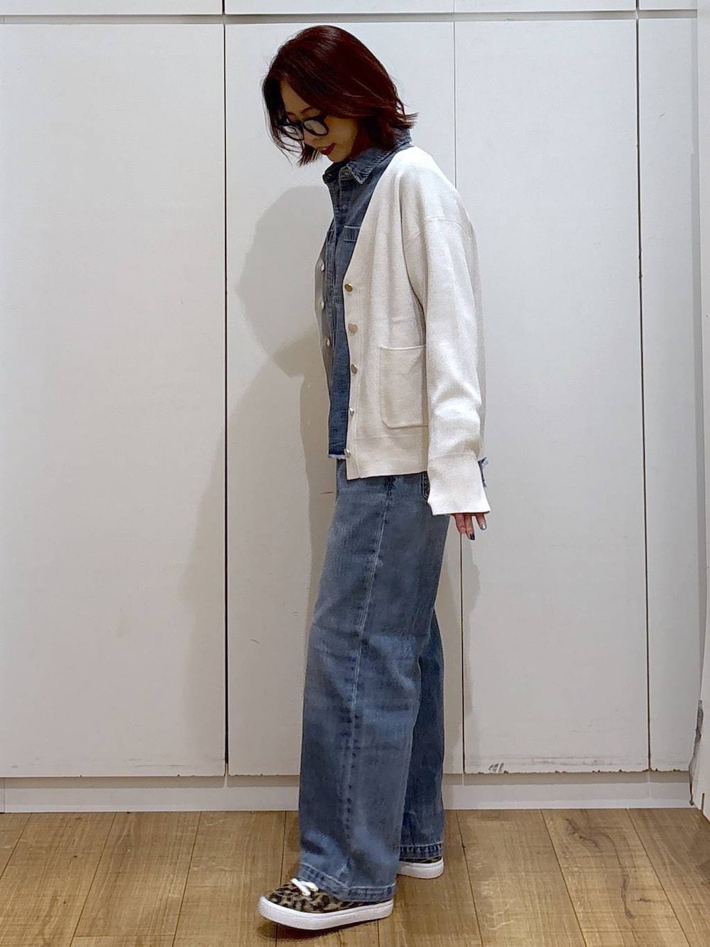 ブルー系のデニムパンツ、ベージュ系のカーディガン/ボレロ、ブルー系のシャツ/ブラウスを着用したレディースの春コーディネートの4枚目の写真