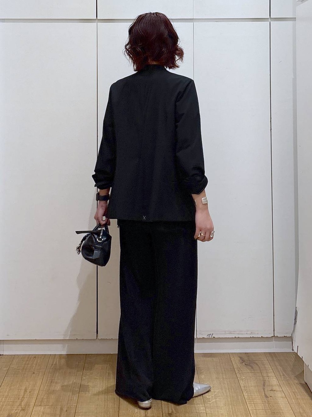 ブラック系のノーカラージャケット、ブラック系のスウェットパンツ、ブラック系のキャミソールを着用したレディースの春コーディネートの4枚目の写真