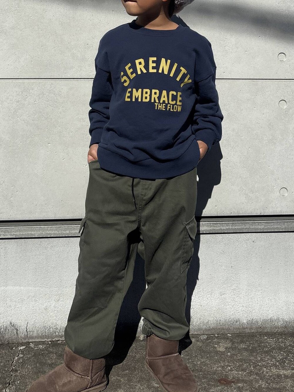 ブルー系のスウェット、グリーン系のカーゴパンツ、ブラウン系のブーツを着用したキッズの秋コーディネートの3枚目の写真