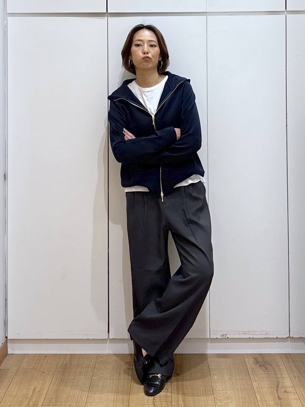 ブラック系のローファー、ブルー系のパーカー、グレー系のその他パンツを着用したレディースの秋コーディネートの2枚目の写真