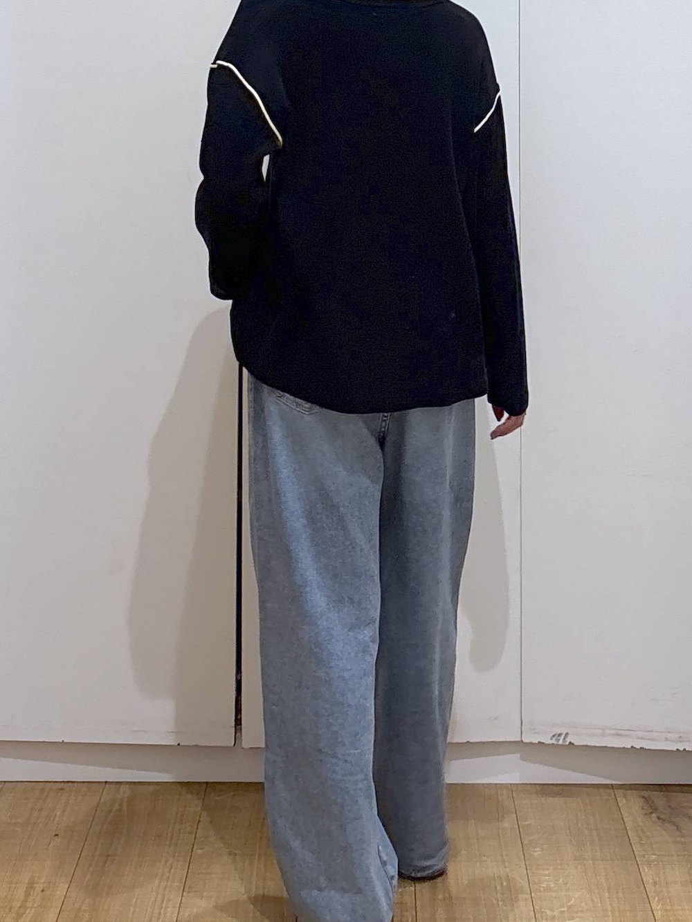 ブルー系のデニムパンツ、ブラック系のワンピース、ブラック系のブーツを着用したレディースの冬コーディネートの3枚目の写真