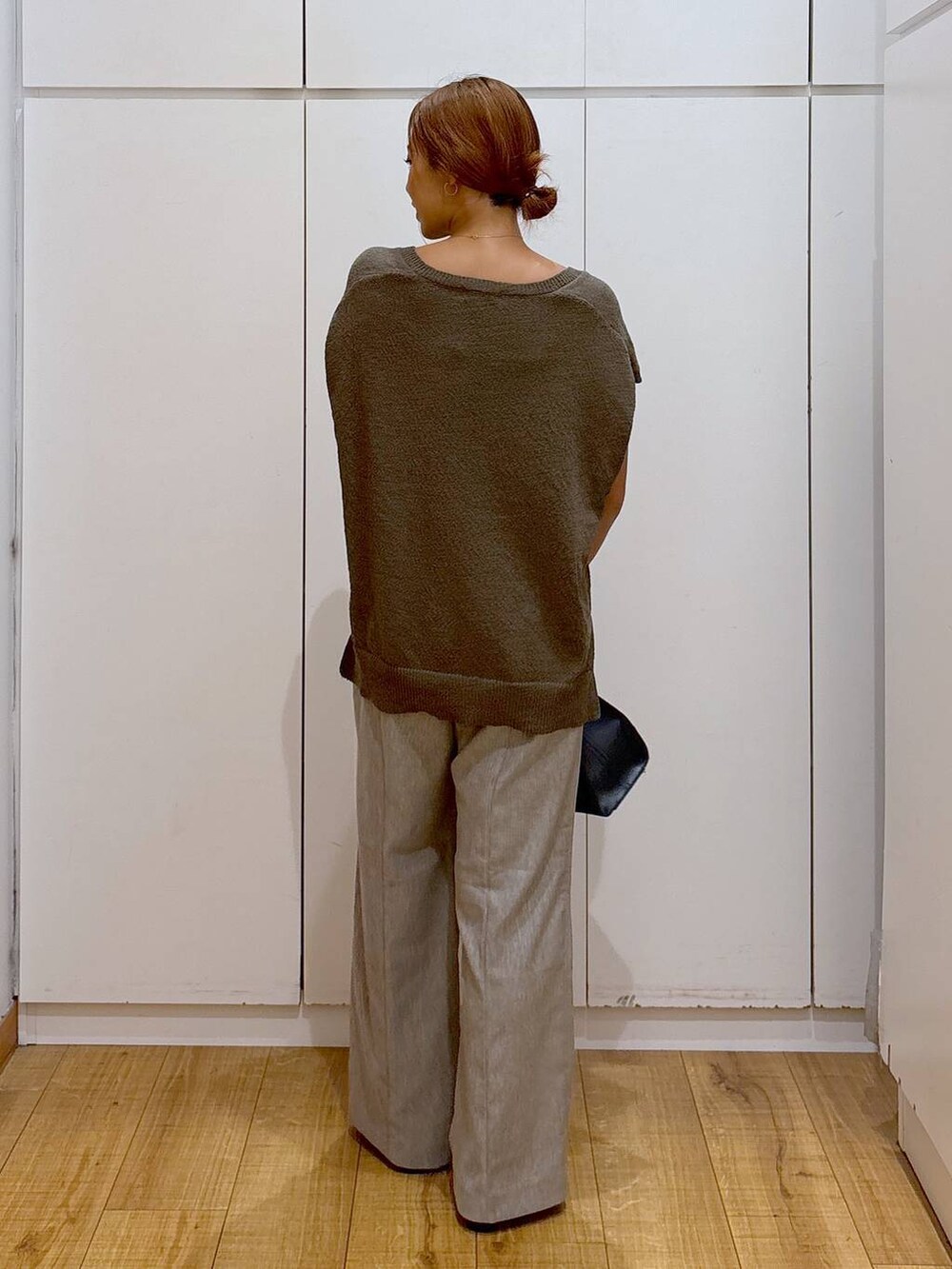 ブラック系のキャミソール、ブラウン系のベスト、ベージュ系のその他パンツを着用したレディースの秋コーディネートの4枚目の写真