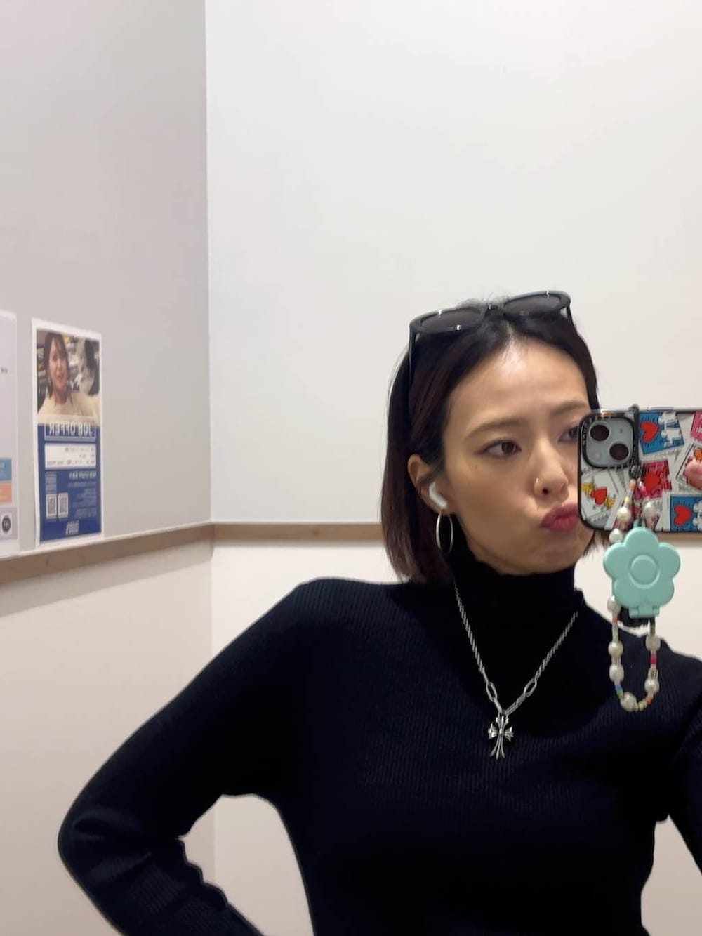 ブラック系のステンカラーコート、ブラック系のニット/セーター、グレー系のスウェットパンツを着用したレディースの冬コーディネートの2枚目の写真