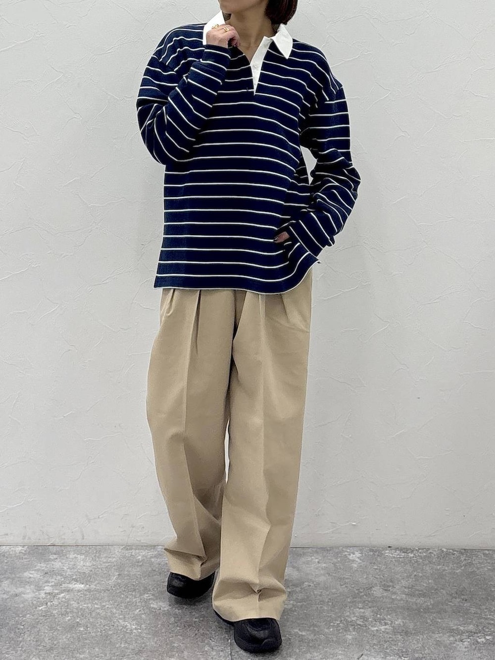 ブラック系のスニーカー、ベージュ系のチノパンツ、グリーン系のスウェットを着用したレディースの冬コーディネートの3枚目の写真