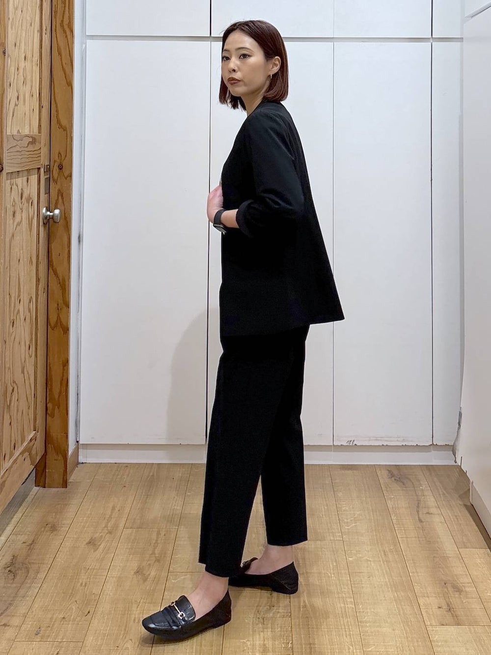 ブラック系のローファー、ブラック系のスラックス、ブラック系のノーカラージャケットを着用したレディースの春コーディネートの6枚目の写真