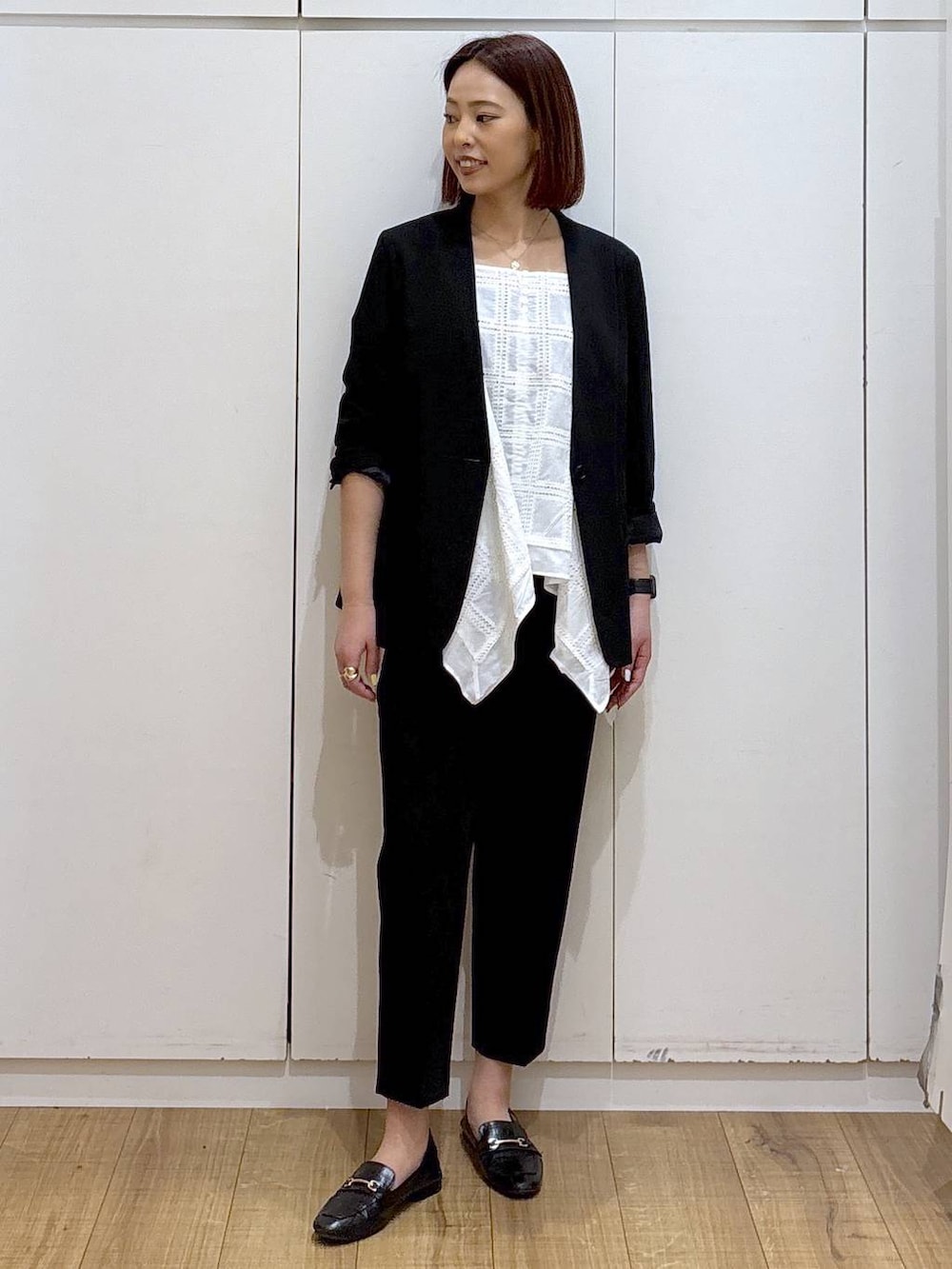 ブラック系のローファー、ブラック系のスラックス、ブラック系のノーカラージャケットを着用したレディースの春コーディネートの2枚目の写真