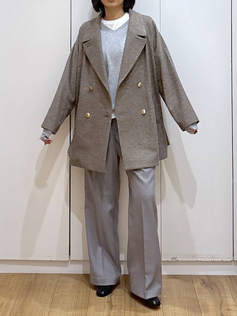 ブラウン系のチェスターコート、グレー系のその他パンツ、ホワイト系のTシャツ/カットソーを着用したレディースの秋コーディネートの7枚目の写真