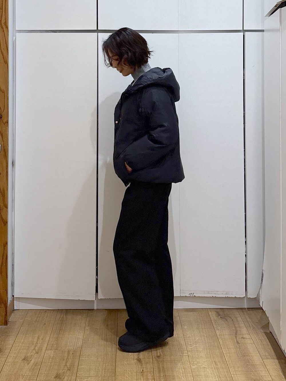 ブルー系のダウンジャケット/コート、グレー系のニット/セーター、ブラック系のその他パンツを着用したレディースの冬コーディネートの2枚目の写真