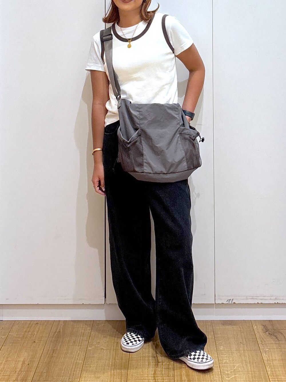 グレー系のトートバッグ、ブラック系のデニムパンツ、ホワイト系のタンクトップを着用したレディースの夏コーディネートの6枚目の写真