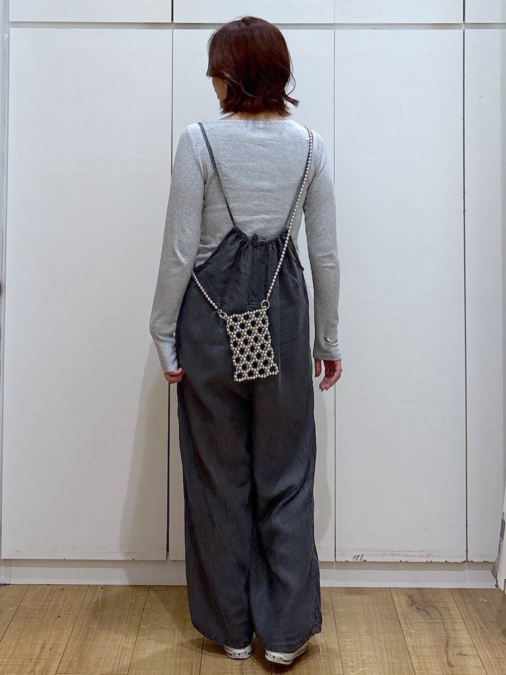 ブラック系のサロペット/オーバーオール、グレー系のスマホグッズを着用したレディースの春コーディネートの4枚目の写真