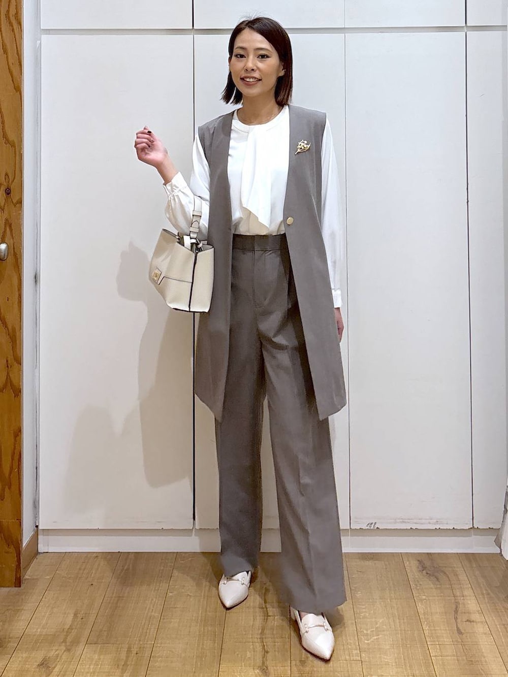 ブラウン系のスラックス、ホワイト系のシャツ/ブラウス、ブラウン系のその他アウターを着用したレディースの冬コーディネートの3枚目の写真