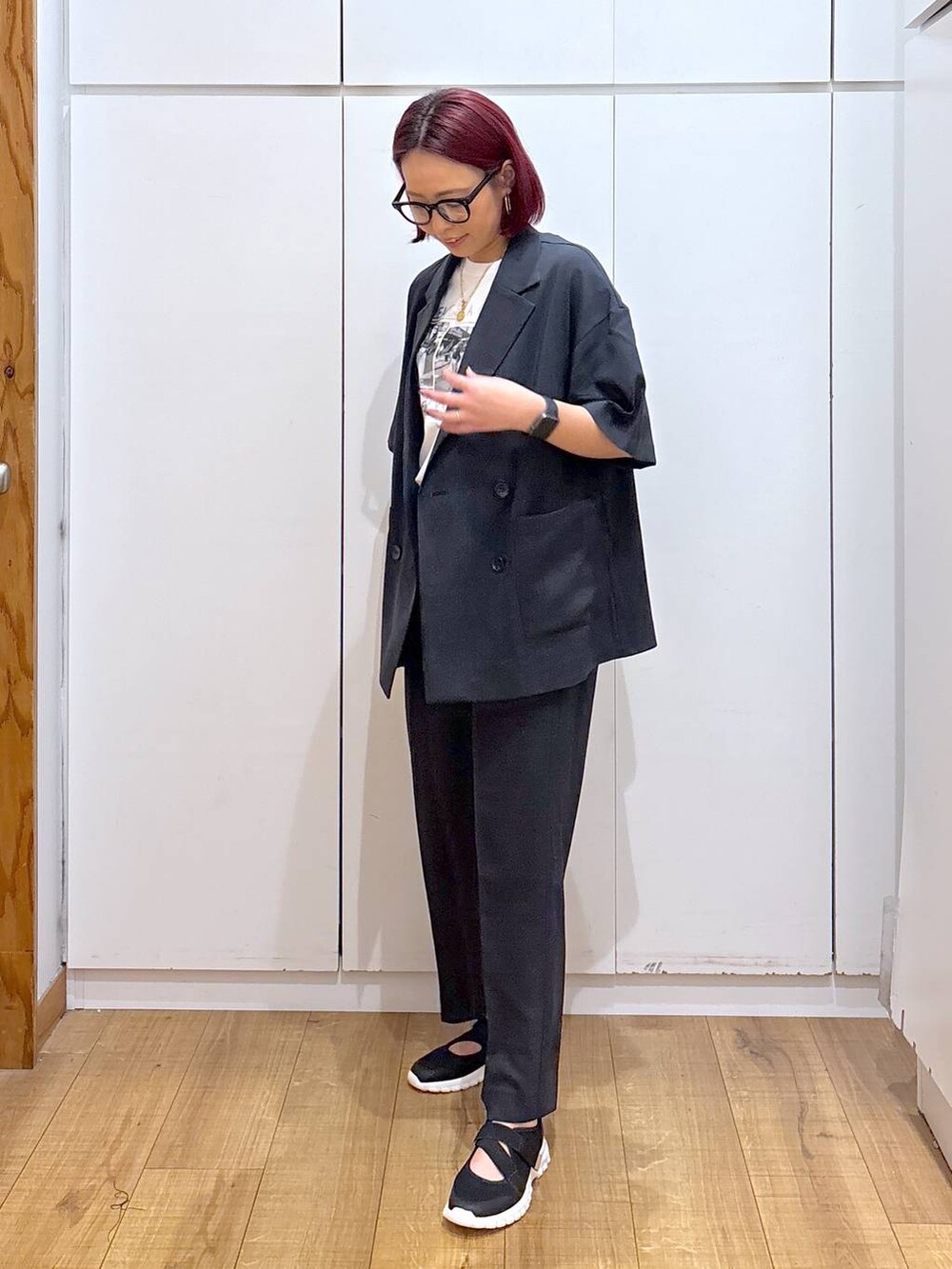 ブラック系のスニーカー、ブラック系のテーラードジャケット、ホワイト系のTシャツ/カットソーを着用したレディースの春コーディネートの4枚目の写真