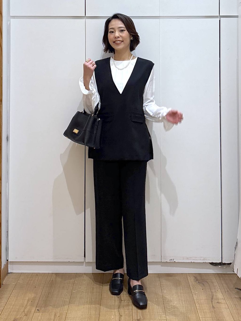 ブラック系のローファー、ブラック系のセットアップ、ブラック系のショルダーバッグを着用したレディースの冬コーディネートの7枚目の写真