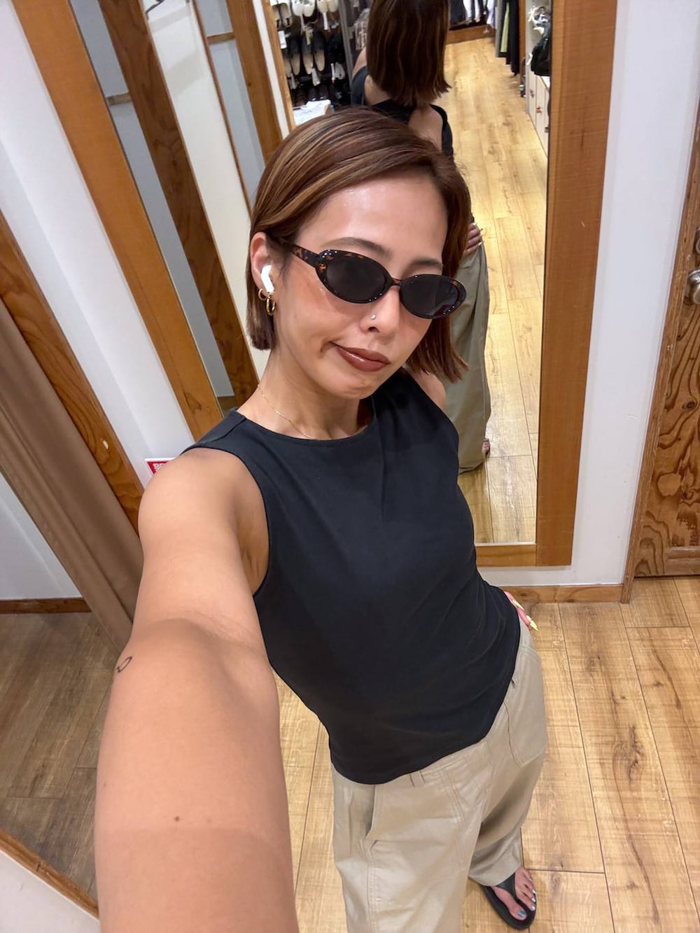 ベージュ系のその他パンツ、ブラック系のサンダルを着用したレディースの夏コーディネートの3枚目の写真