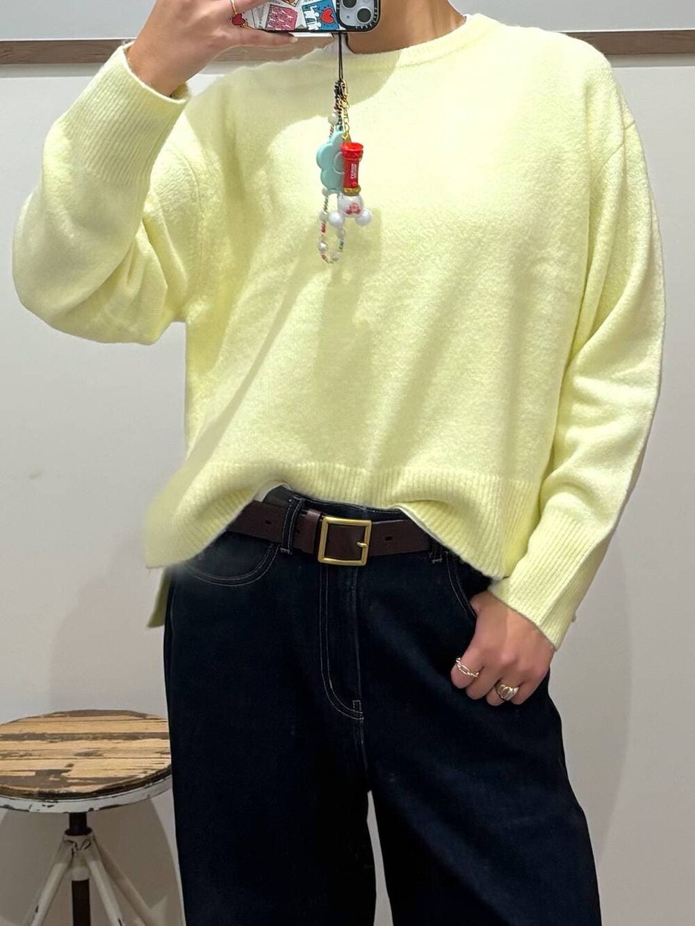 ブルー系のデニムパンツ、ベージュ系のローファー、イエロー系のニット/セーターを着用したレディースの冬コーディネートの2枚目の写真