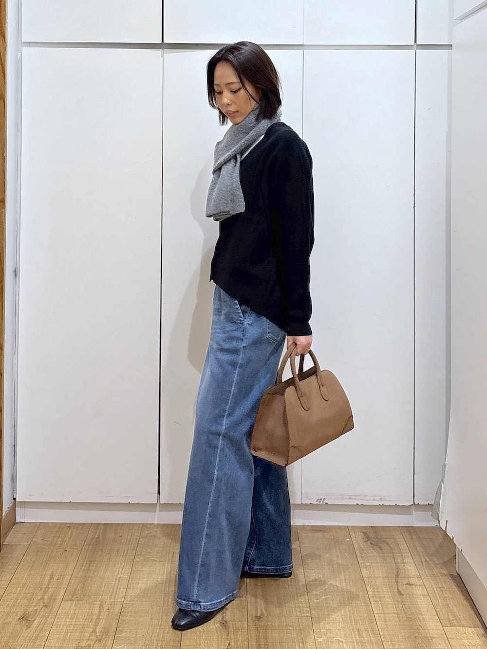 ブラック系のカーディガン/ボレロ、ベージュ系のショルダーバッグ、ブラック系のブーツを着用したレディースの秋コーディネートの4枚目の写真