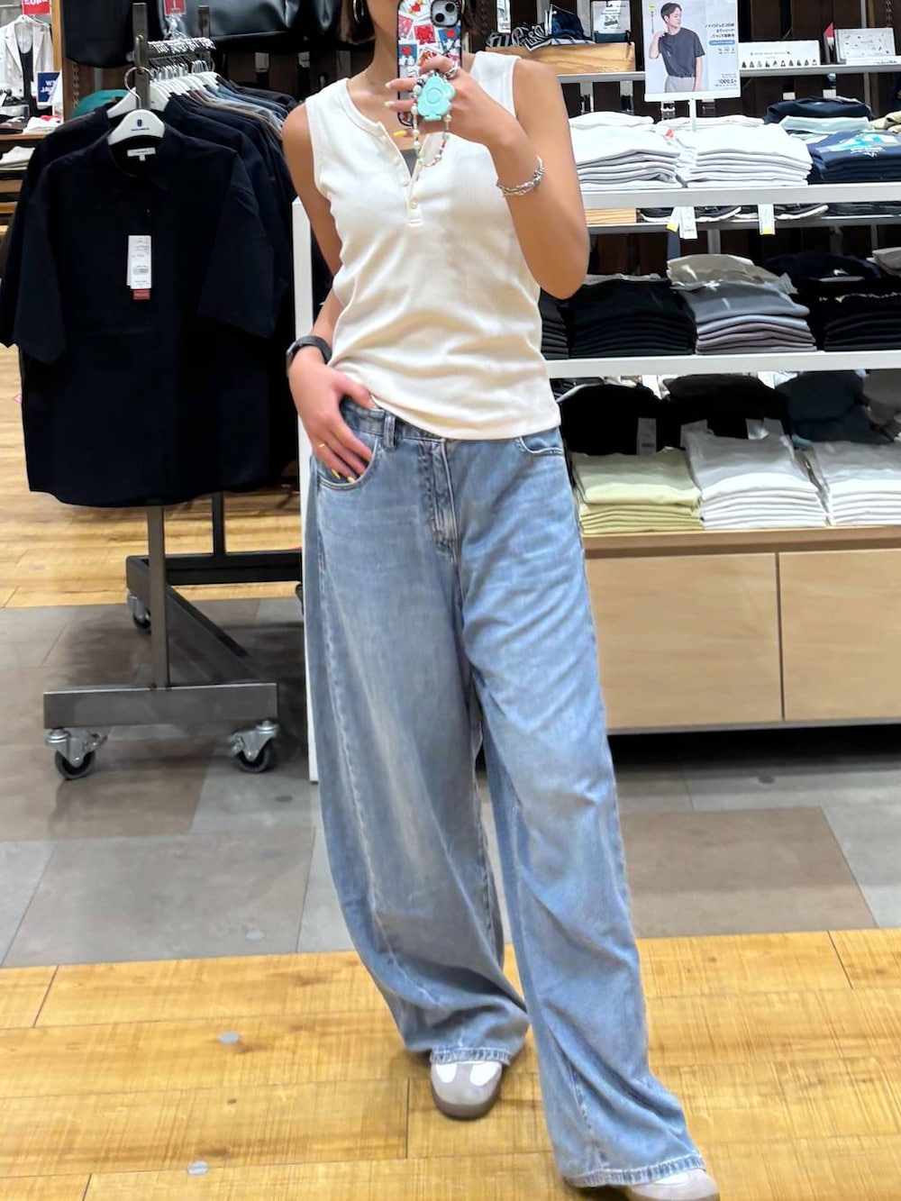 ブルー系のデニムパンツ、ホワイト系のタンクトップを着用したレディースの夏コーディネートの3枚目の写真