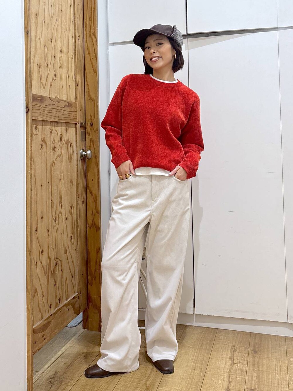 グレー系のその他パンツ、ブラウン系のブーツ、レッド系のニット/セーターを着用したレディースの冬コーディネートの3枚目の写真