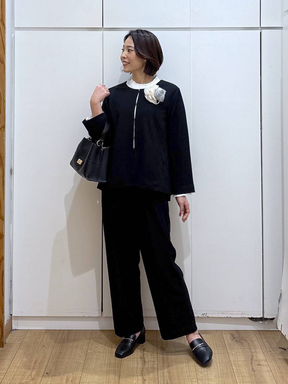 ブラック系のローファー、ブラック系のセットアップ、ブラック系のショルダーバッグを着用したレディースの冬コーディネートの3枚目の写真