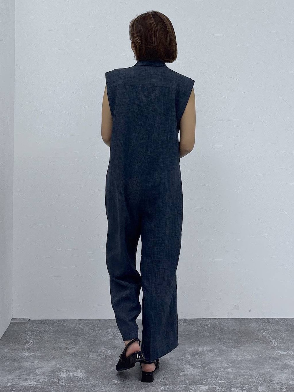 ブラック系のキャミソール、ブラック系のパンプス、ブルー系のつなぎ/オールインワンを着用したレディースの春コーディネートの6枚目の写真