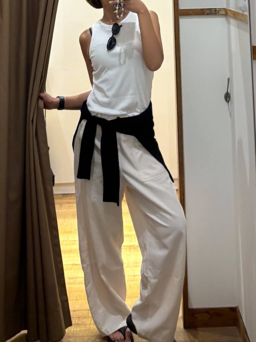 ベージュ系のその他パンツ、ブラック系のカーディガン/ボレロ、ブラック系のサンダルを着用したレディースの夏コーディネートの6枚目の写真