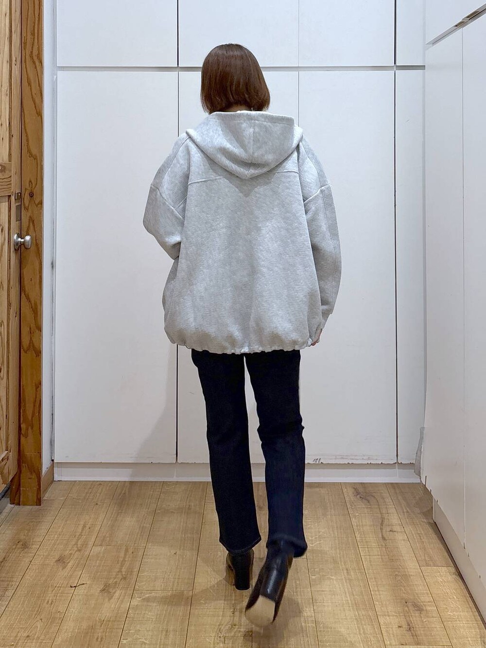 ブルー系のデニムパンツ、ブラック系のニット/セーター、グレー系のブルゾンを着用したレディースの秋コーディネートの3枚目の写真