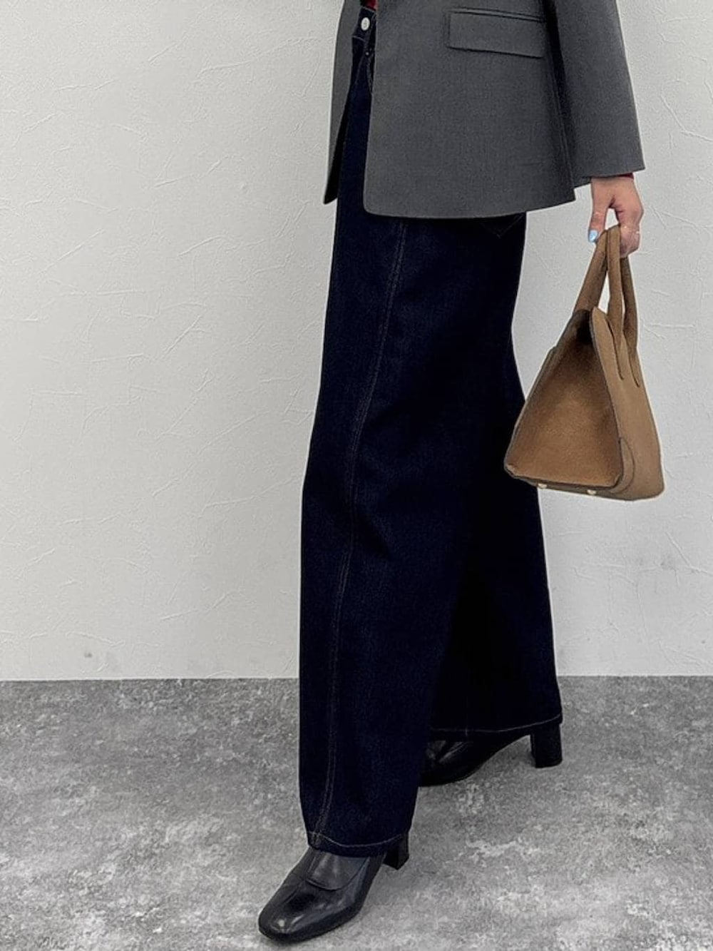 ブラウン系のトートバッグ、グレー系のテーラードジャケット、ブラック系のブーツを着用したレディースの冬コーディネートの5枚目の写真