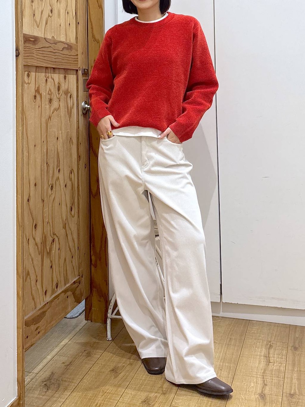 グレー系のその他パンツ、ブラウン系のブーツ、レッド系のニット/セーターを着用したレディースの冬コーディネートの8枚目の写真