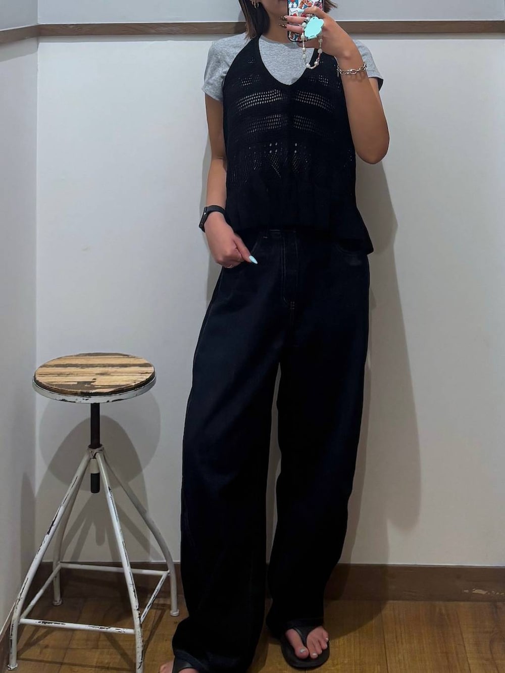 ブルー系のデニムパンツ、ブラック系のサンダル、ブラック系のベストを着用したレディースの春コーディネートの7枚目の写真