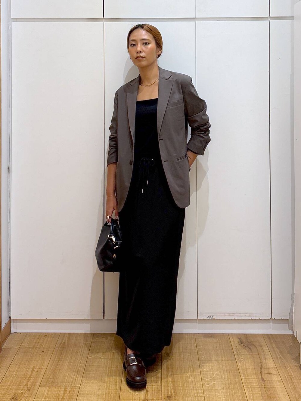 ブラック系のショルダーバッグ、ブラウン系のローファー、ブラック系のキャミソールを着用したレディースの秋コーディネートの2枚目の写真