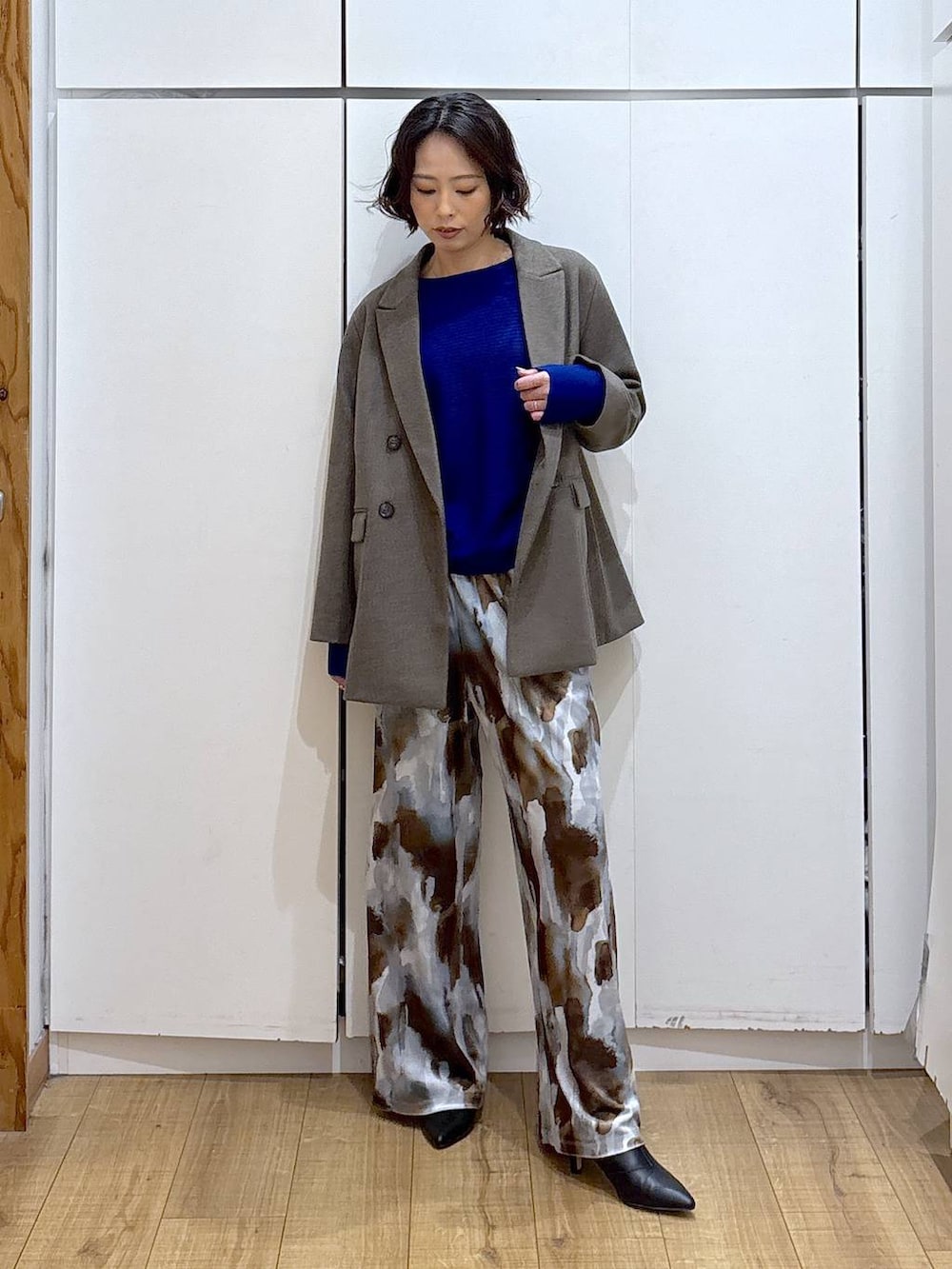 ブルー系のニット/セーター、ブラウン系のテーラードジャケット、ブラック系のブーツを着用したレディースの冬コーディネートの2枚目の写真