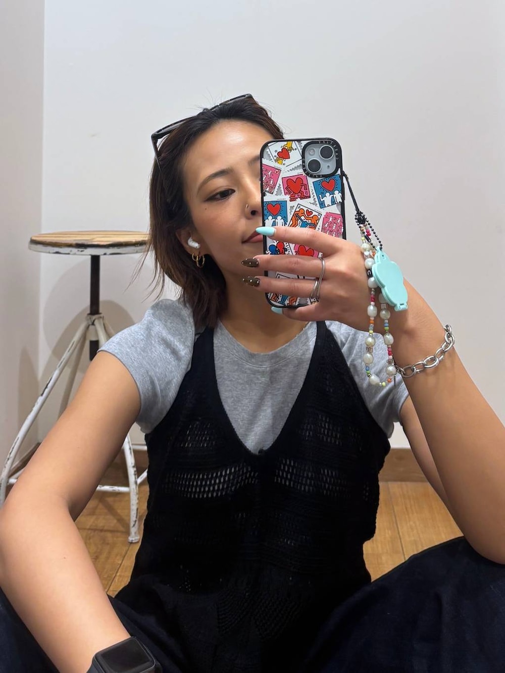 ブルー系のデニムパンツ、ブラック系のサンダル、ブラック系のベストを着用したレディースの春コーディネートの4枚目の写真