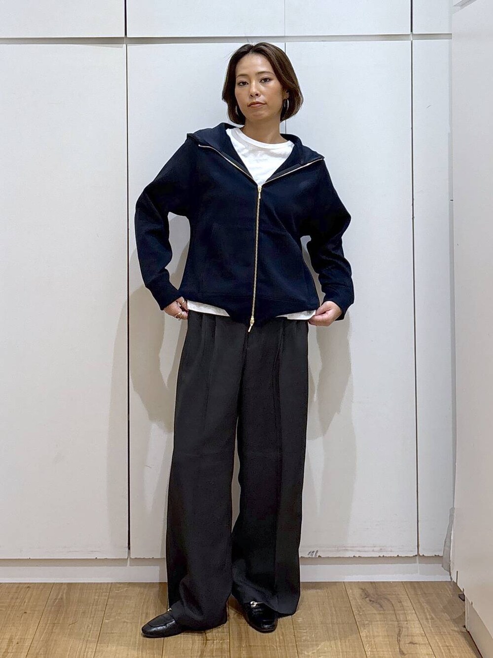 ブラック系のローファー、ブルー系のパーカー、グレー系のその他パンツを着用したレディースの秋コーディネートの3枚目の写真