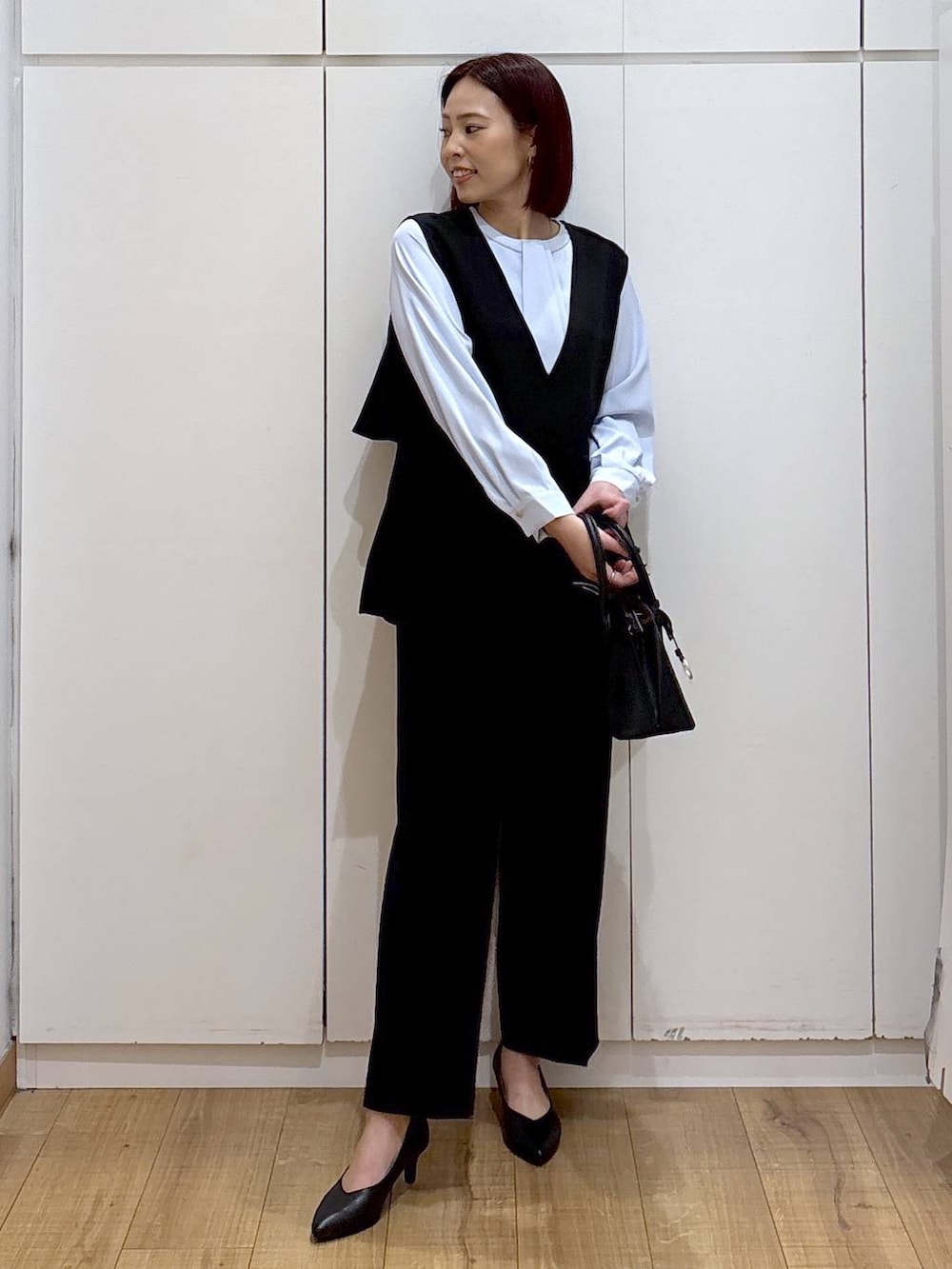 ブラック系のショルダーバッグ、ブラック系のパンプス、ブルー系のシャツ/ブラウスを着用したレディースの春コーディネートの4枚目の写真