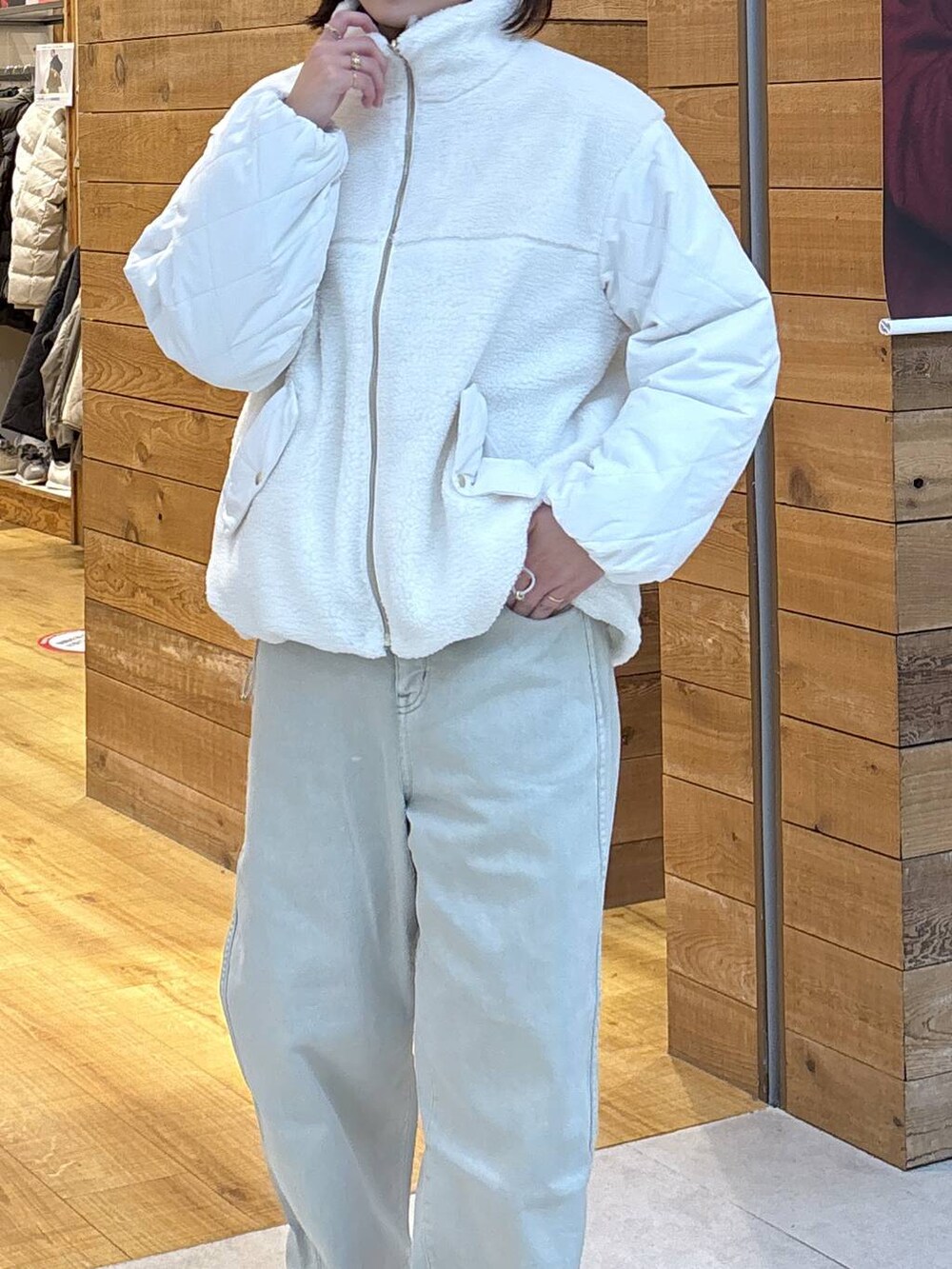 ホワイト系のブルゾン、ベージュ系のデニムパンツ、グレー系のスウェットを着用したレディースの秋コーディネートの6枚目の写真