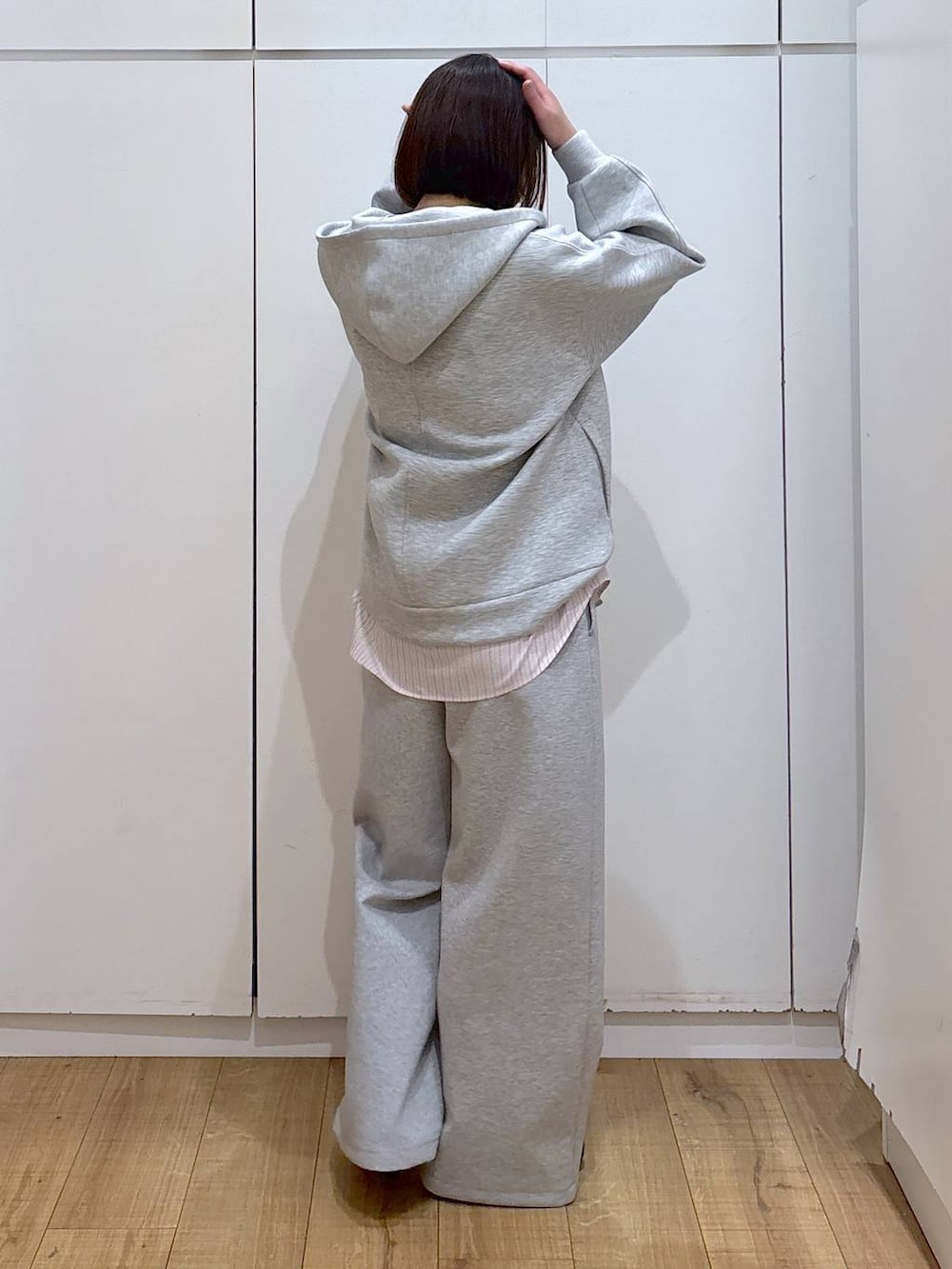 ブラウン系のスニーカー、ピンク系のシャツ/ブラウス、ベージュ系のステンカラーコートを着用したレディースの冬コーディネートの3枚目の写真