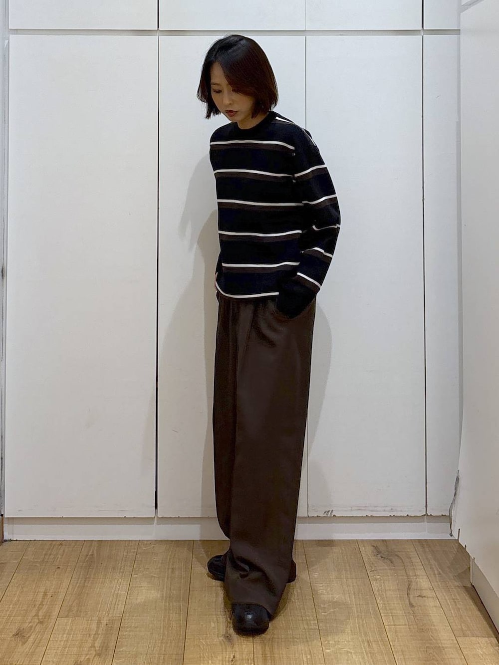 ブラック系のスニーカー、ブラウン系のその他パンツを着用したレディースの冬コーディネートの4枚目の写真