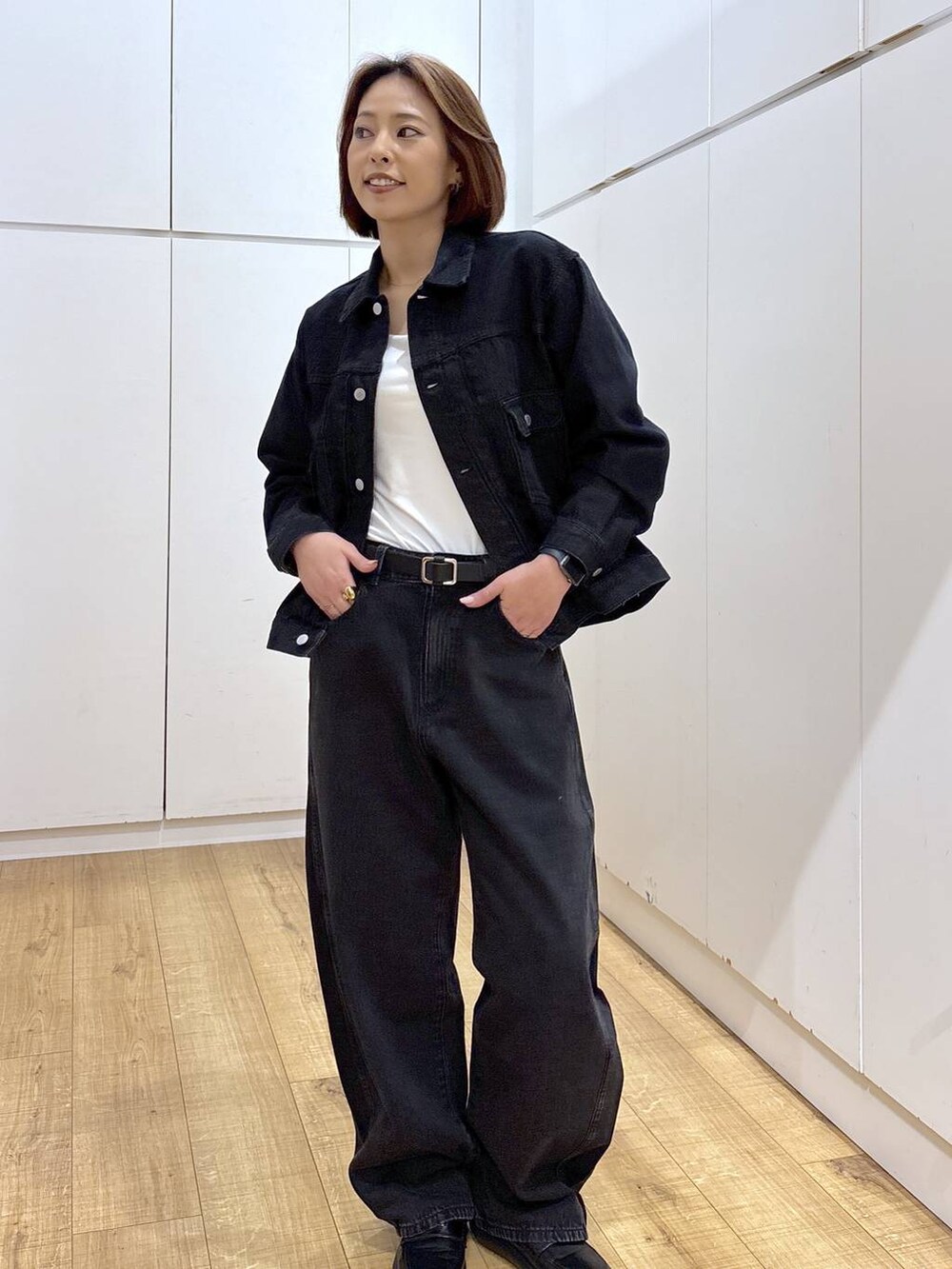 ブラック系のデニムパンツ、ブラック系のデニムジャケット、ホワイト系のキャミソールを着用したレディースの春コーディネートの3枚目の写真