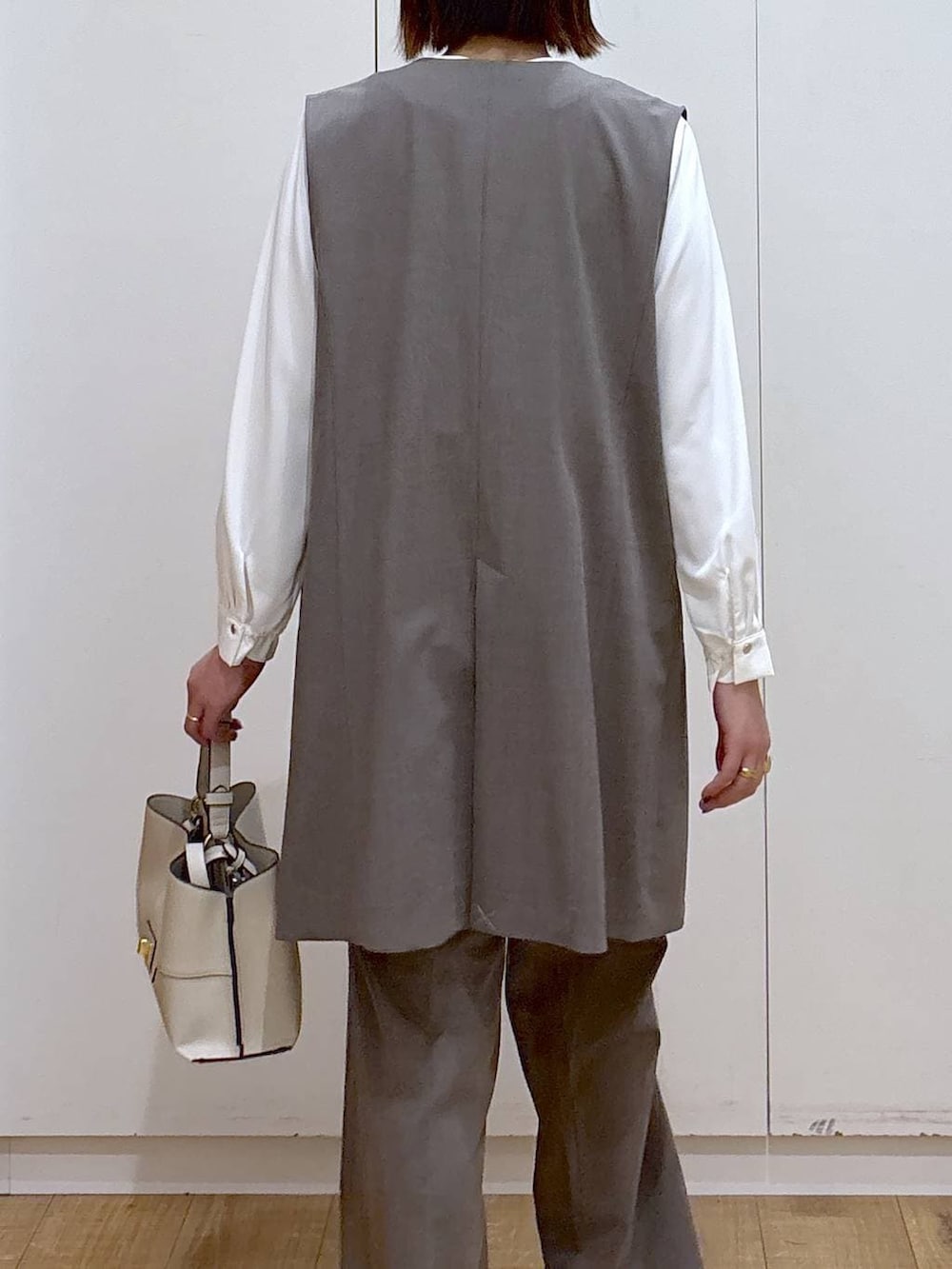 ブラウン系のスラックス、ホワイト系のシャツ/ブラウス、ブラウン系のその他アウターを着用したレディースの冬コーディネートの5枚目の写真