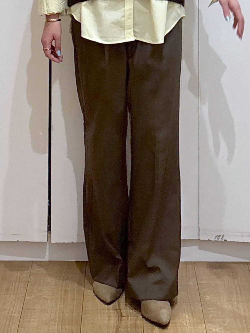 イエロー系のシャツ/ブラウス、ブラウン系のニット/セーター、ブラウン系のその他パンツを着用したレディースの冬コーディネートの4枚目の写真