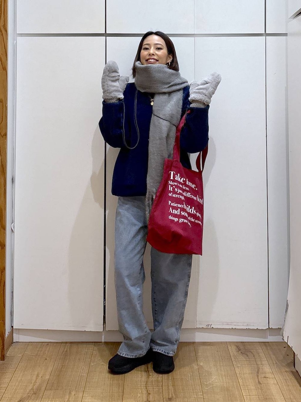 ブルー系のデニムパンツ、ホワイト系のTシャツ/カットソー、レッド系のトートバッグを着用したレディースの冬コーディネートの3枚目の写真