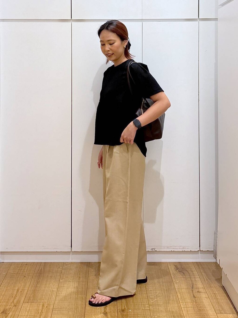 ベージュ系のその他パンツ、ブラック系のTシャツ/カットソー、ブラウン系のサンダルを着用したレディースの夏コーディネートの3枚目の写真