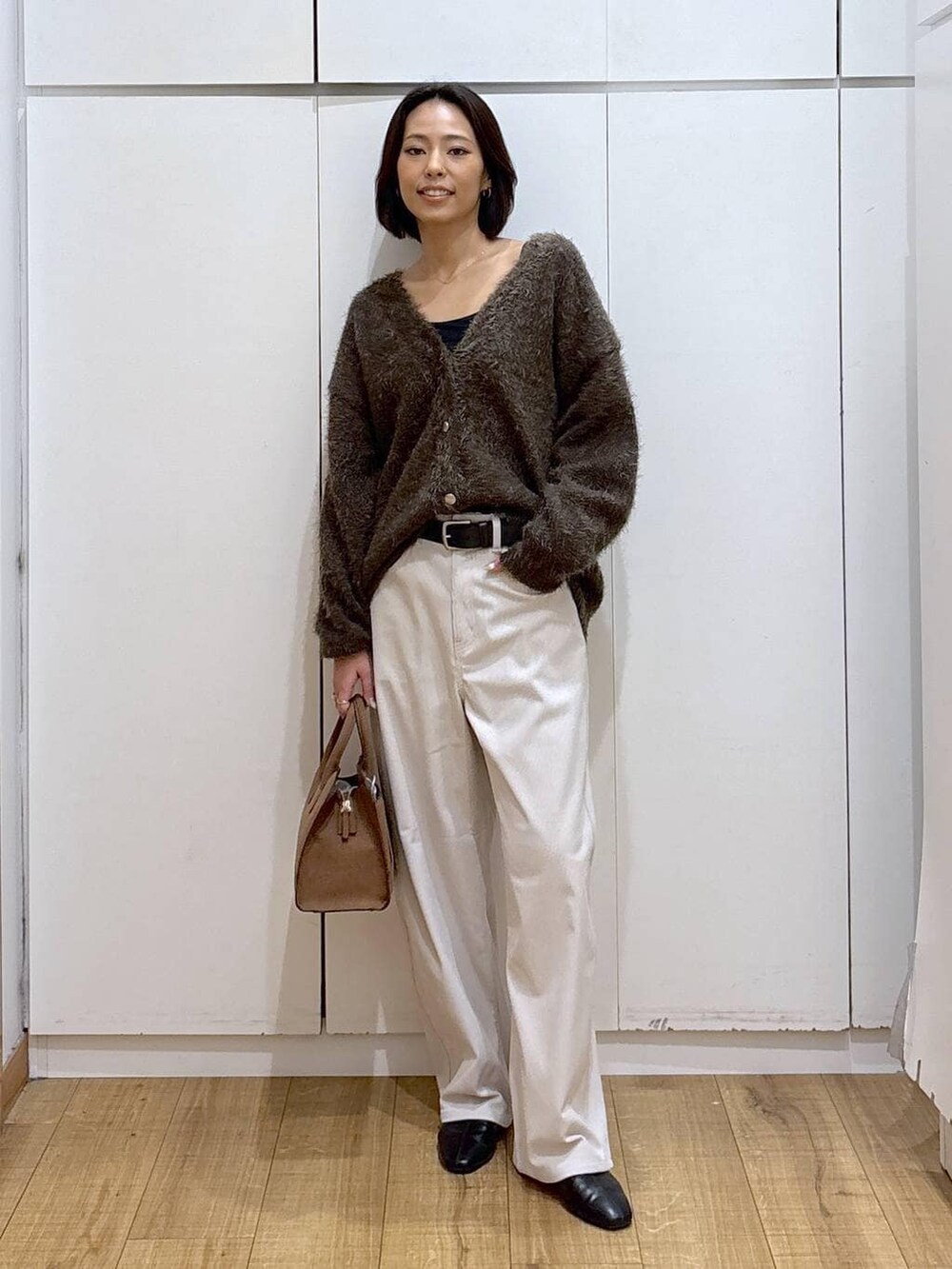 グレー系のその他パンツ、ベージュ系のショルダーバッグ、ブラウン系のカーディガン/ボレロを着用したレディースの秋コーディネートの2枚目の写真