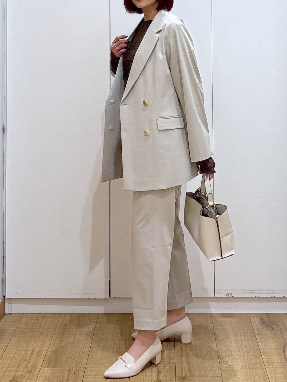 ベージュ系のスラックス、ベージュ系のテーラードジャケット、ベージュ系のショルダーバッグを着用したレディースの春コーディネートの4枚目の写真