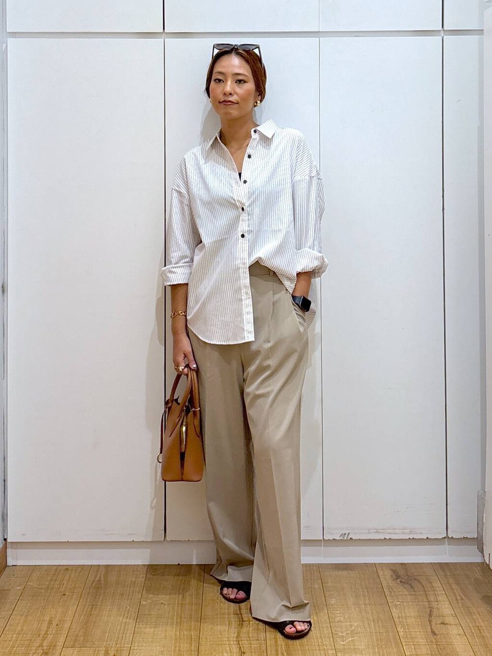 ブラウン系のショルダーバッグ、ベージュ系のその他パンツ、その他のシャツ/ブラウスを着用したレディースの秋コーディネートの2枚目の写真