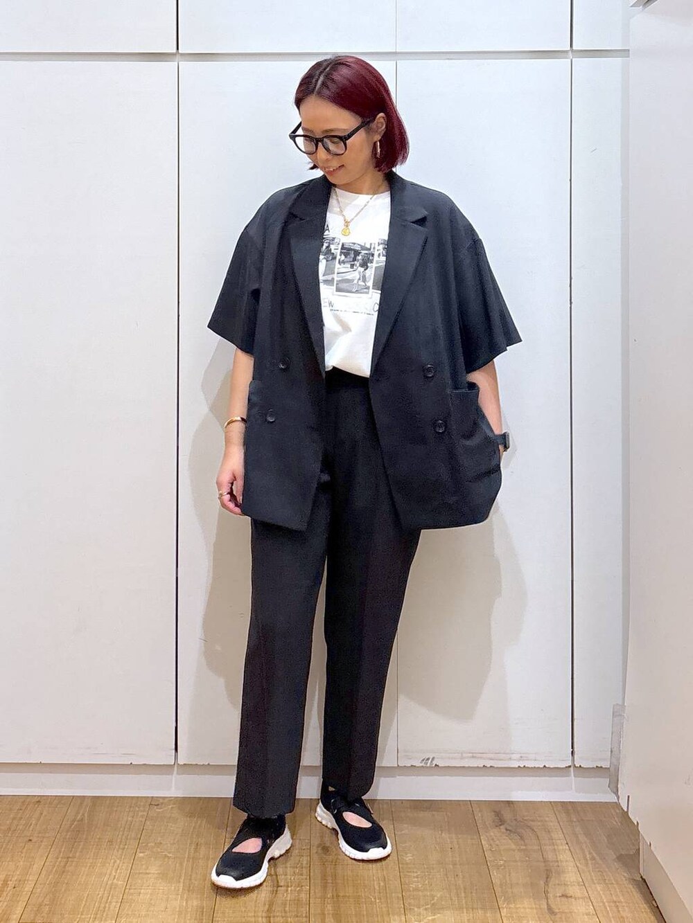 ブラック系のスニーカー、ブラック系のテーラードジャケット、ホワイト系のTシャツ/カットソーを着用したレディースの春コーディネートの3枚目の写真