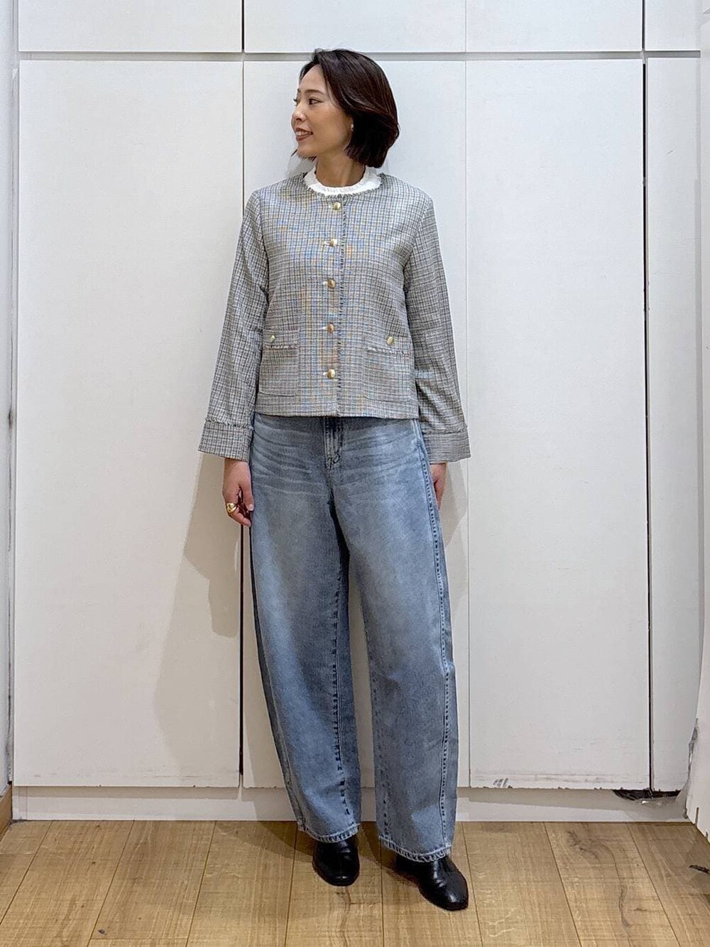 ブラック系のセットアップ、ホワイト系のテーラードジャケット、ブラック系のブーツを着用したレディースの冬コーディネートの4枚目の写真